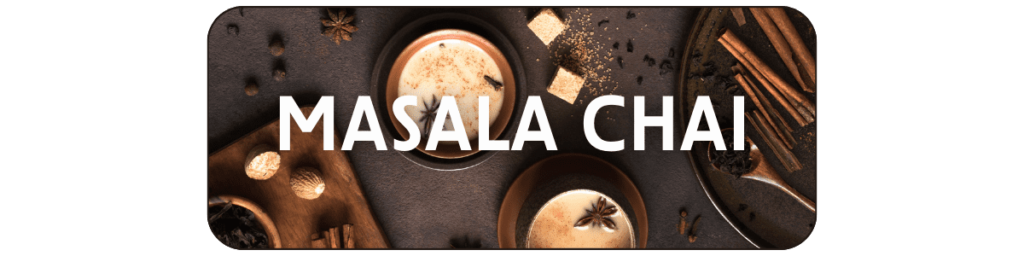 Masala Chai - two mugs of creamy masala chai, surrounded by sugar cubes, cinnamon, star anise, and more traditional spices.